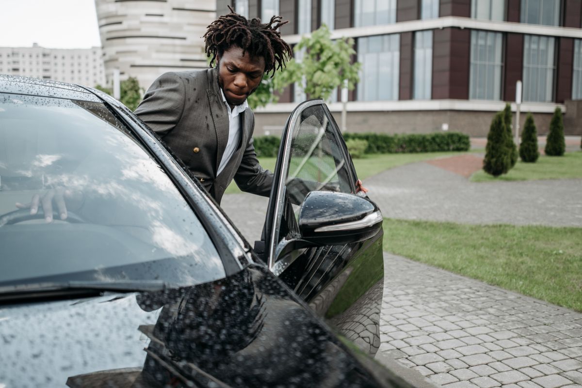 Business traveller stepping out of a car