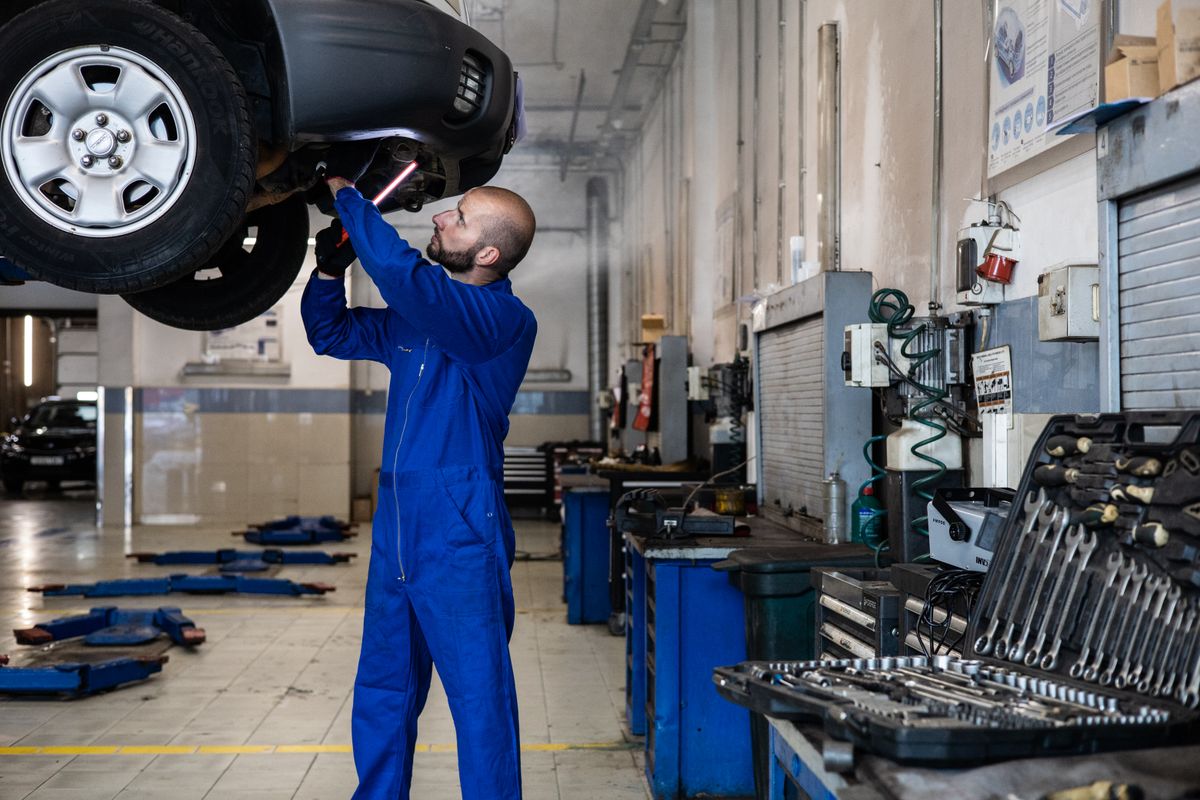 Mechanic inspecting a vehicle on a lift